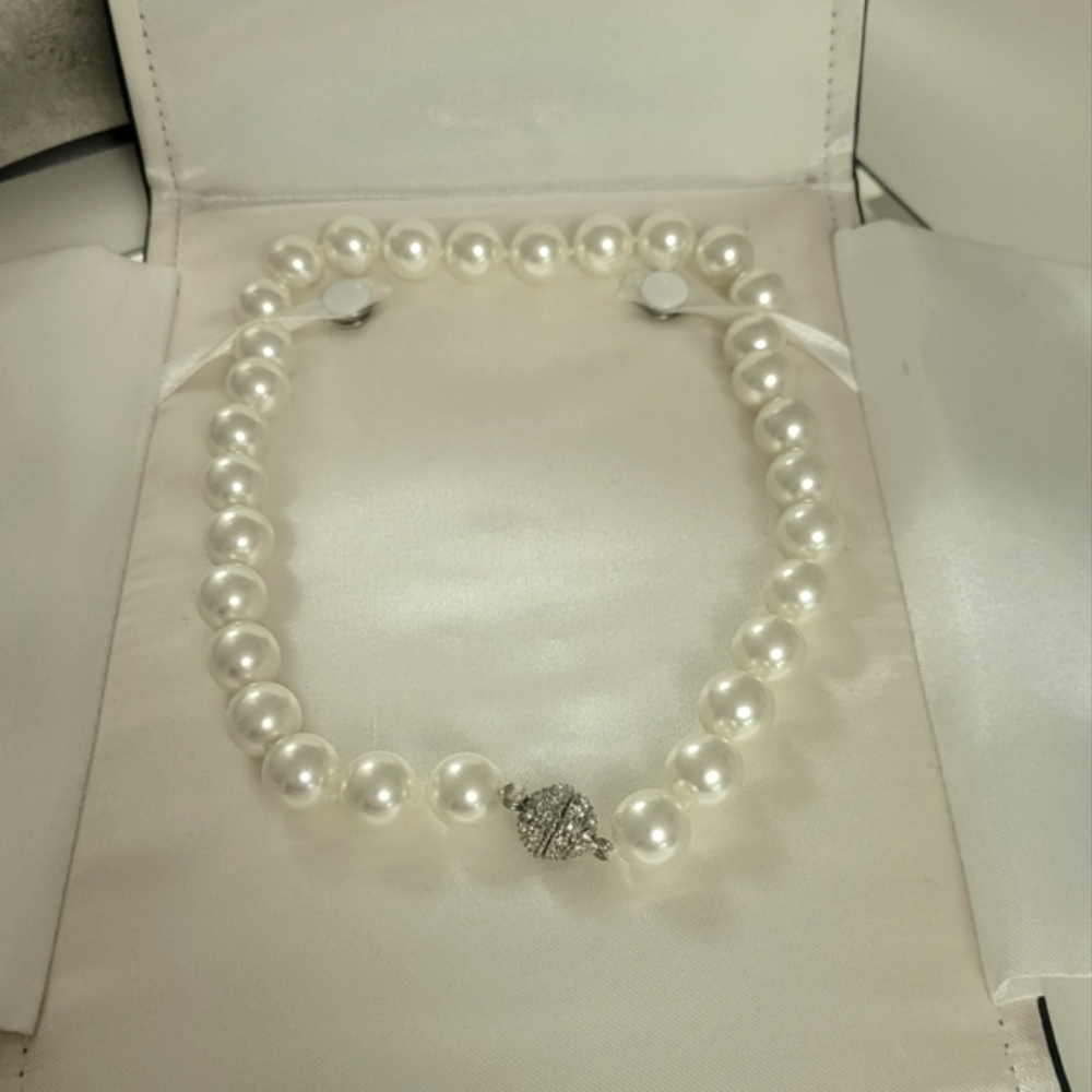 Chunky pearl necklace with central crystal covered twist clasp